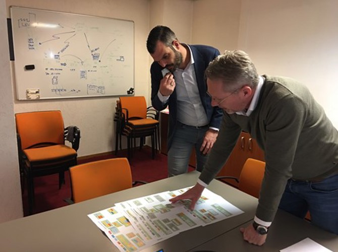 Een man die naar een papier op een tafel wijst