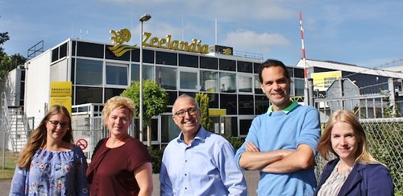 Een groep mensen die voor een gebouw staat