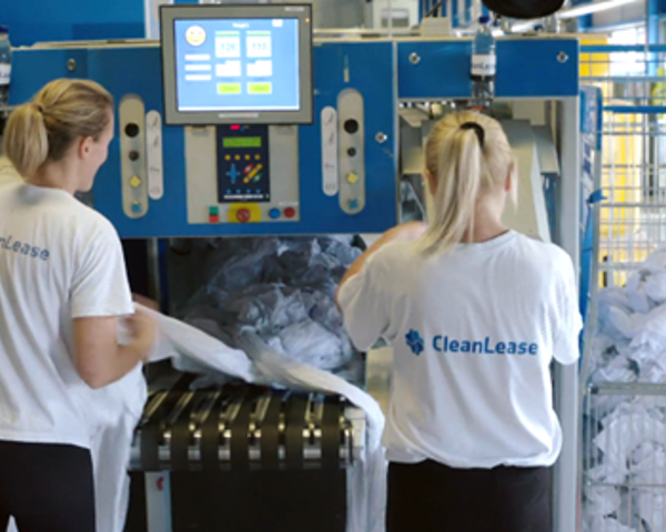 Een vrouw in witte overhemden die naast een machine staat