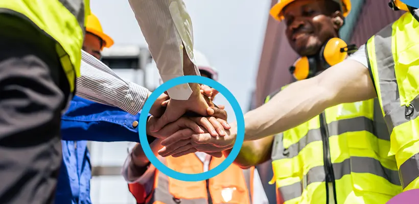 Een groep mensen in een cirkel die handen stapelt