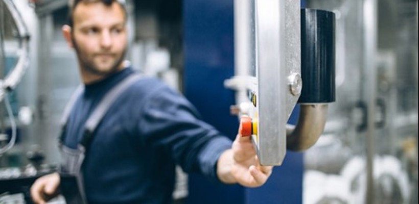 Een man die op een knop op een machine drukt